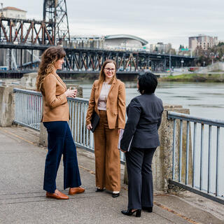 Three Ferguson Wellman employees talking outside by the water