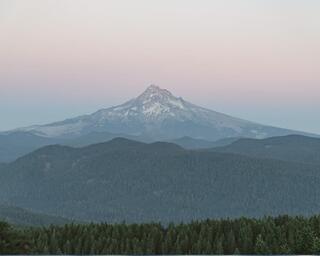 A view of Mt. Hood with light blue and pink tones from sunset